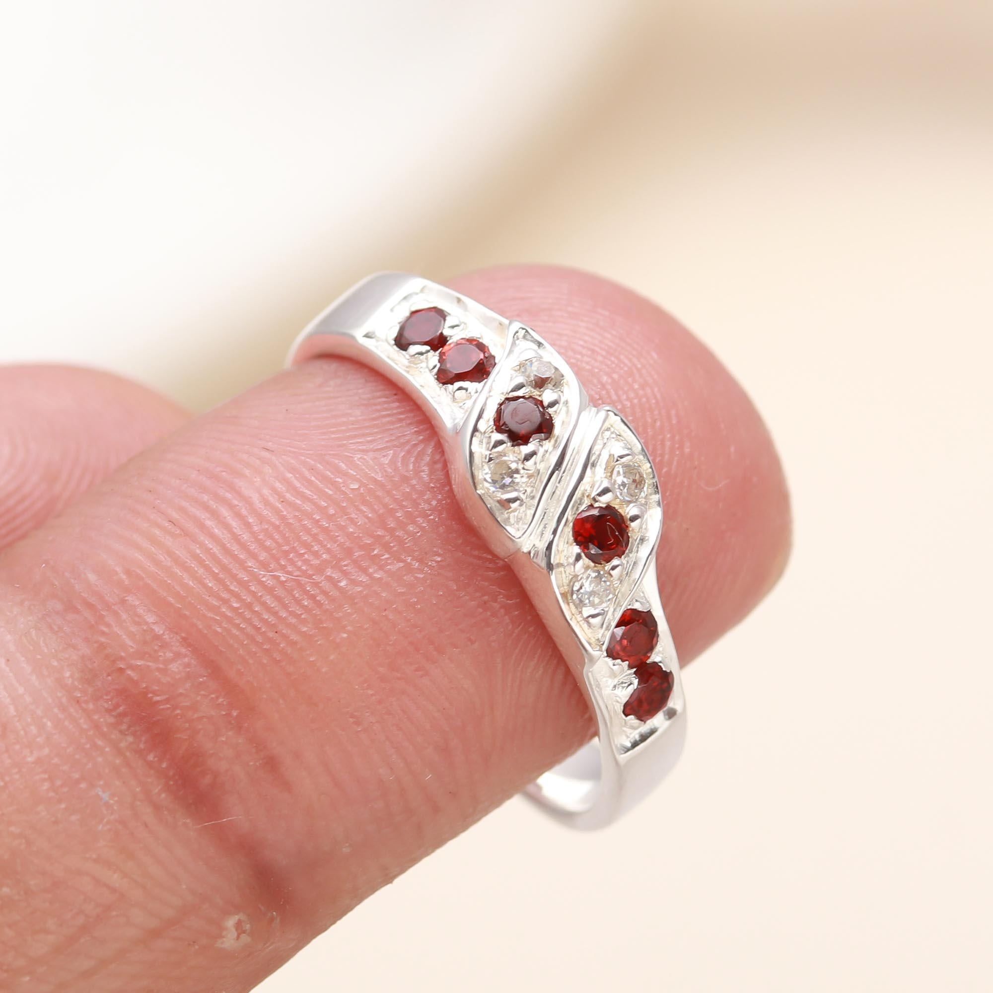 Stylish sterling silver garnet twist ring on finger