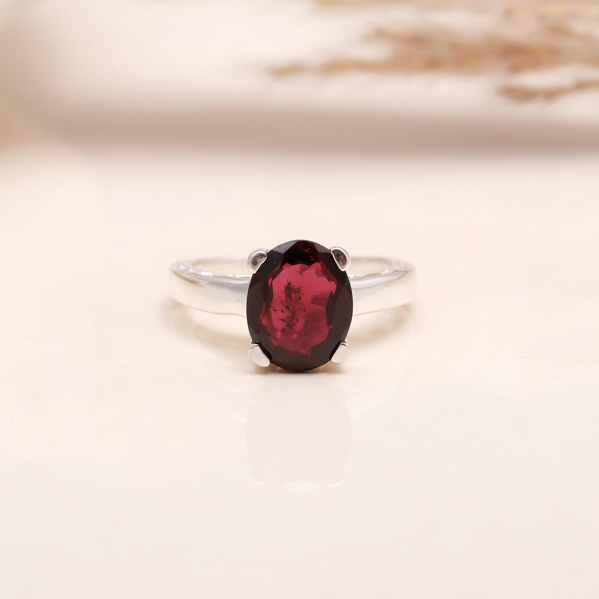 Close-up of oval red garnet solitaire ring