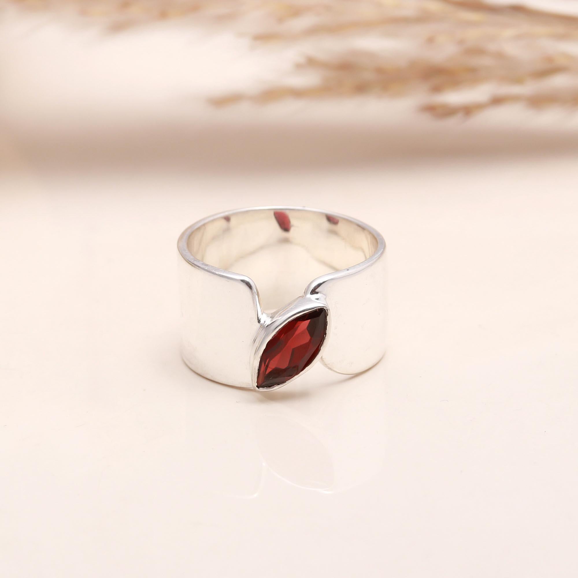Close-up of marquise garnet open band silver ring