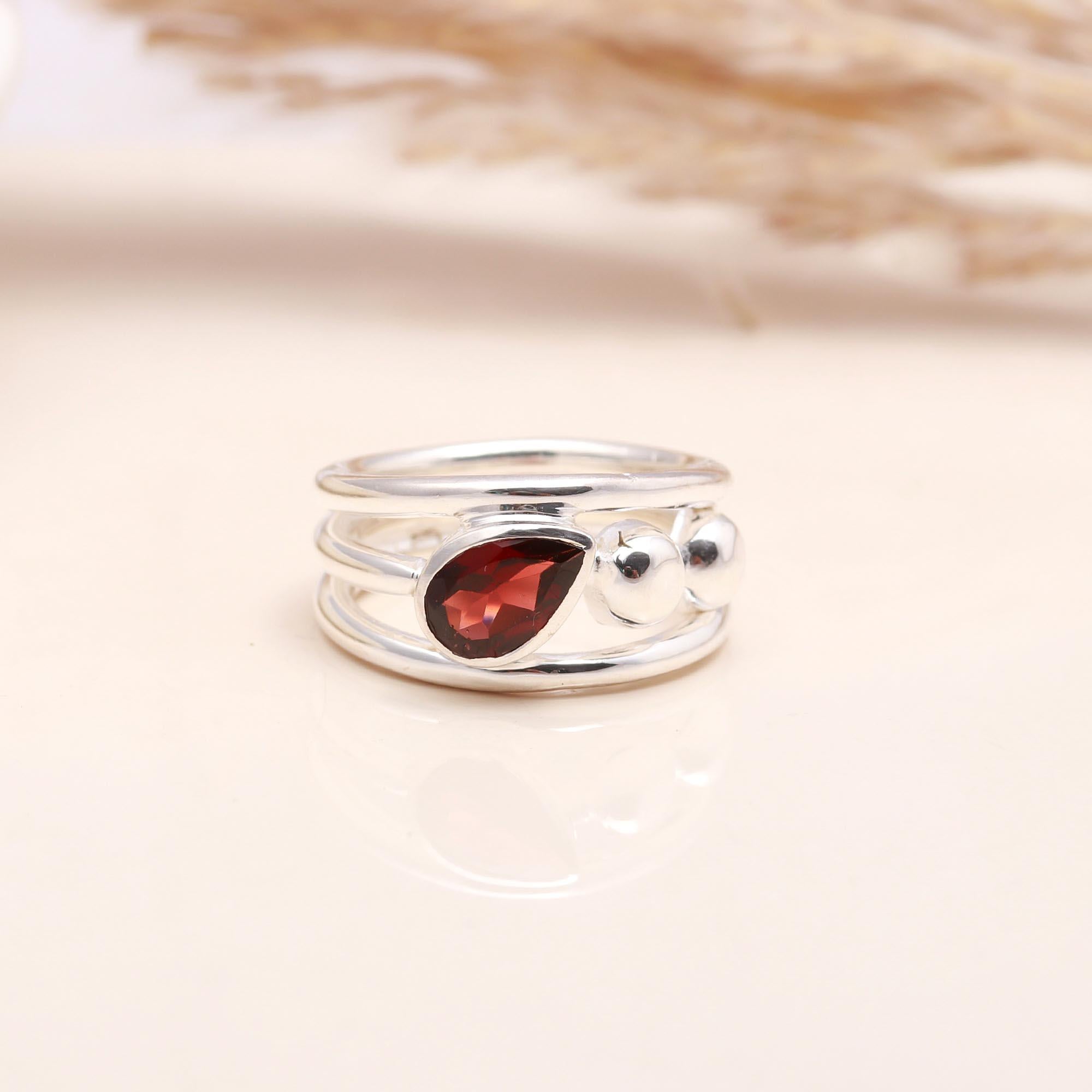 Close-up of pear-cut garnet in sterling silver split band ring