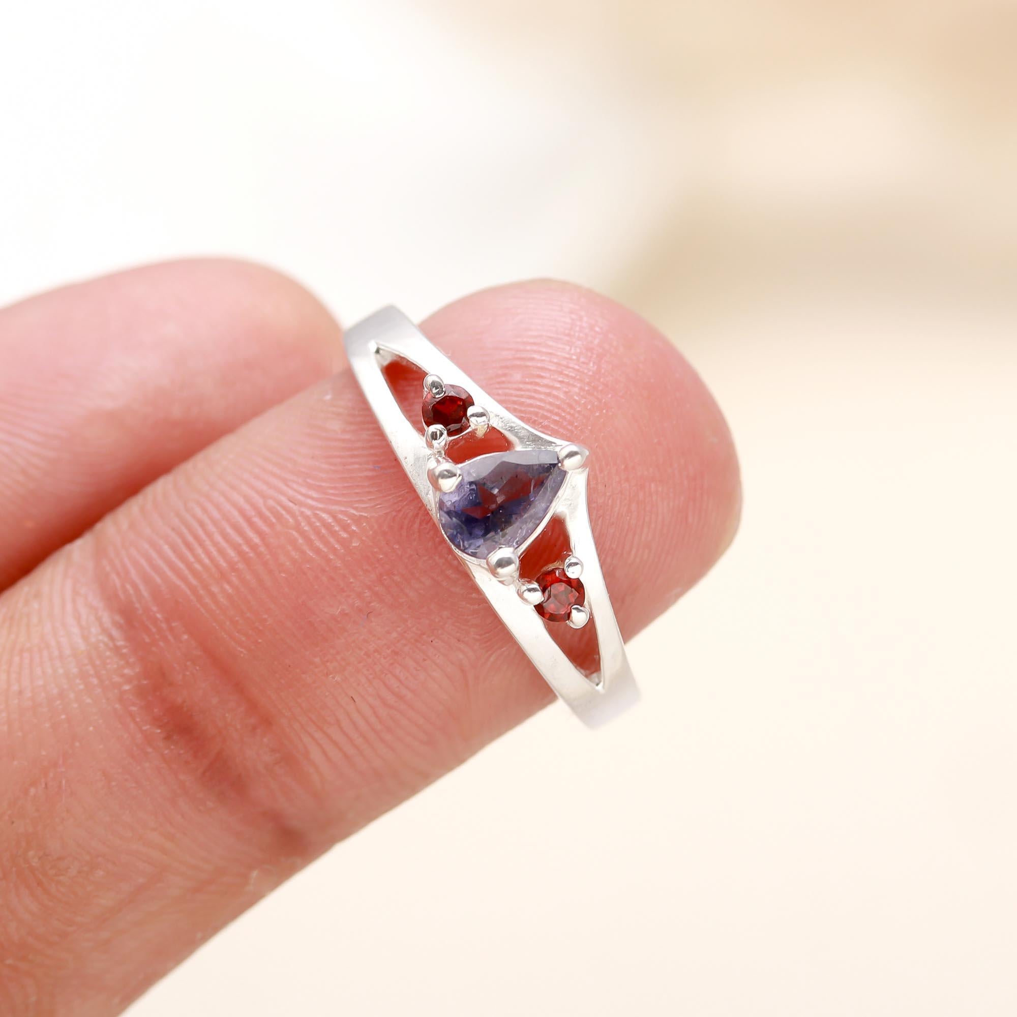 Modern split band ring with blue iolite and red garnet gemstones